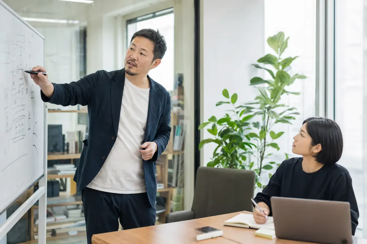 企业负责人在白板前梳理 AI 项目的投入产出口径